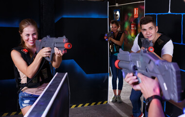 .team of players aiming from laser pistols to an opponentplaying laser tag (first-person view)