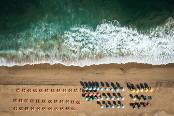 Sombrillas ordenadas en la playa. Arena y mar en vista cenital 