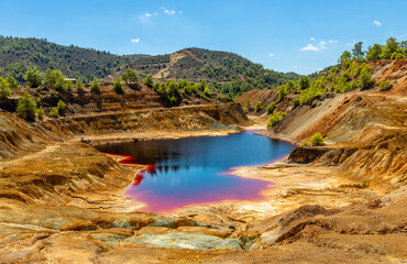 Fototapeta na wymiar Dangerous bloody colored with copper pollution Sha mine lake, Nicosia, Cyprus