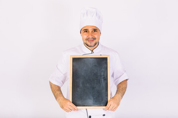 Chef cook in jacket and kitchen hat smiling, holding a board with the menu, on white background