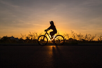 Fototapeta na wymiar Silhouette of cyclist in motion on the background of beautiful sunset