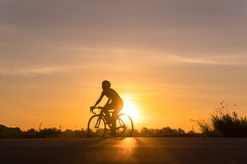 Fototapeta na wymiar Silhouette of cyclist in motion on the background of beautiful sunset
