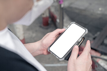 Close up men using a smartphone with empty white screen at the outdoor.