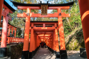 Torii gates perspective view at Fushimi Inari Shinto shrine, a famous place in Kyoto, Japan. Senbon Torii is an impressive pathway with about a thousand torii gates.  Language: 'Inari great god'.