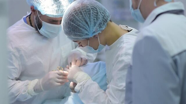 Surgeon and nurse during a dental operation.Anesthetized patient in the operating room.Installation of dental implants or tooth extraction in the clinic. General anesthesia during orthodontic surgery.