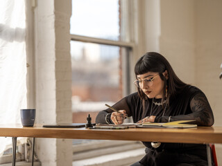 Non binary Indigenous artist drawing indoors