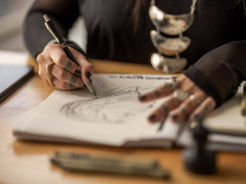 Non binary Indigenous artist drawing indoors