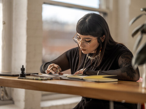 Non binary Indigenous artist drawing indoors