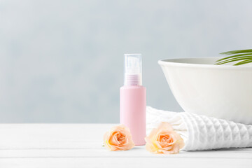 Spa set with bottle of cosmetic on light background