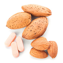 Almond nuts and pills on white background