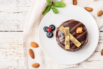 Plate with tasty cocoa cake on table