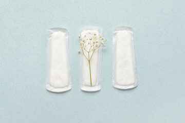 Menstrual pads and gypsophila flowers on color background