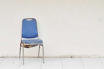 old worn chair with white wall stock photo. copy space