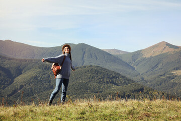 Fototapeta na wymiar Young woman in beautiful mountains on sunny day