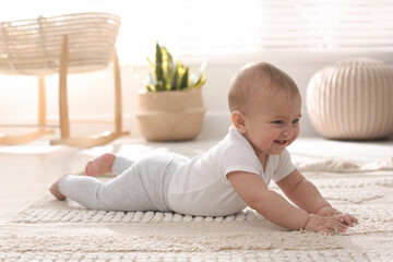 Cute baby crawling on floor at home