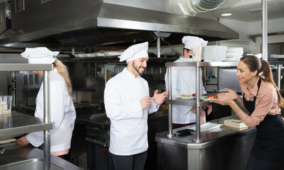 Fototapeta na wymiar Staff of restaurant with head chef working together in kitchen