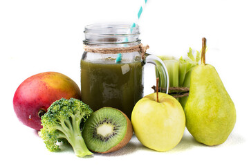 Blended green smoothie with ingredients on white background.