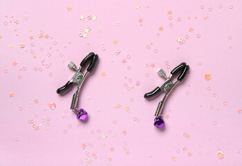 Nipple clamps on color background - obrazy, fototapety, plakaty