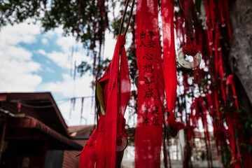 Believers wrote their wishes on strips of red cloth before throwing them to hook on the branch of a wishing tree. Prior to that, they prayed for their wishes to come true at the nearby temple.