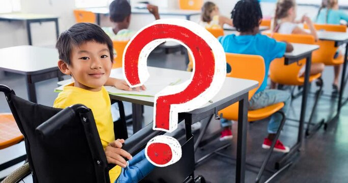 Animation of red question mark over smiling asian schoolboy in wheelchair at desk in classroom