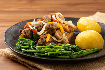 Cooked ribs with potatoes and watercress.