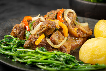 Cooked ribs with potatoes and watercress.