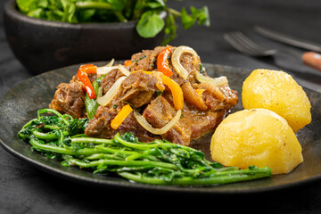 Cooked ribs with potatoes and watercress.