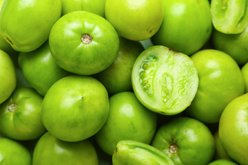 Fresh green tomatoes as background, closeup