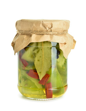 Jar with canned green tomatoes on white background