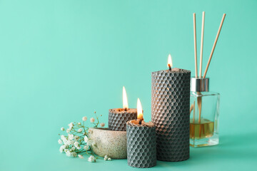 Composition with glowing candles on green background