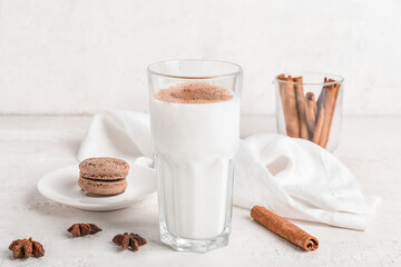 Glass of tasty coffee with cinnamon on white background