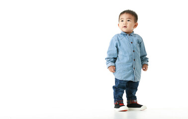 Handsome little Asian boy on long sleeved shirt for smart outfit standing with confident and sparkling eyes, chin up, and smile for hopeful expectation of beautiful childhood lifestyle.