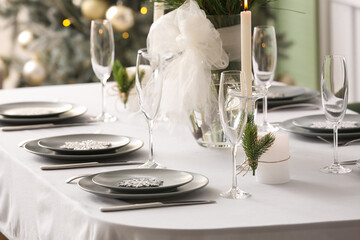 Dining table with beautiful setting for Christmas celebration in festive room