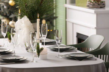 Dining table with beautiful setting for Christmas celebration in festive room