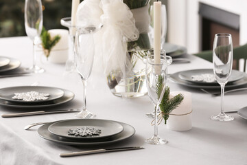 Dining table with beautiful setting for Christmas celebration in festive room