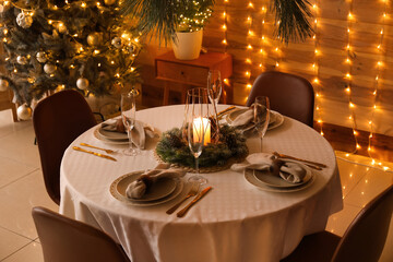 Dining table with beautiful setting for Christmas celebration in festive room