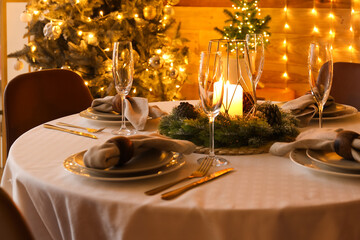 Dining table with beautiful setting for Christmas celebration in festive room