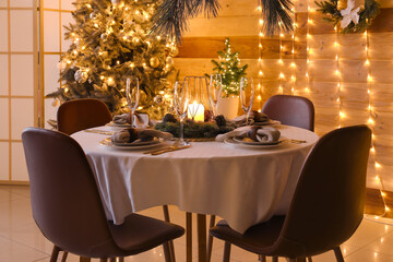 Dining table with beautiful setting for Christmas celebration in festive room