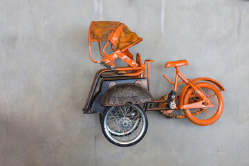 Miniature of becak the Indonesian traditional rikshaw transport hanging on the wall for decoration