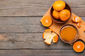 Bowl of tasty tangerine jam on wooden background