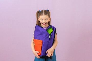 The schoolgirl looks into her school bag and smiles.