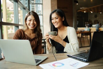 two women working on laptop