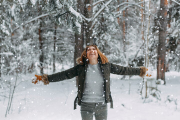 Snow in the air on the background of a blurry image of a happy young girl who throws white snow. Christmas holidays, Winter time