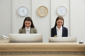 Beautiful receptionists working at counter in hotel