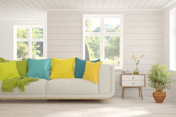 Fototapeta premium Stylish room in white color with sofa and summer landscape in window. Scandinavian interior design. 3D illustration