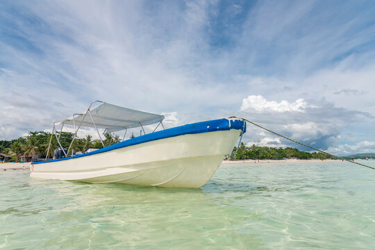 A Skiff Boat Docked In Shallow Waters At Dumaluan Beach In Panglao, Bohol. Low Angle Shot.