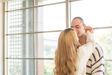 Fototapeta premium Male and female couples or lovers happily snuggle near the windows in the summer.