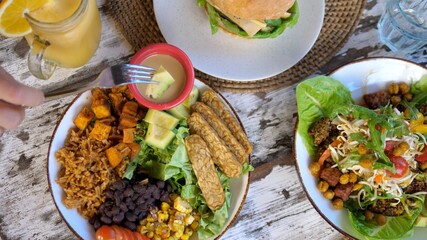 Top view of vegan meal in a restaurant. Dipping avocado in the sauce 