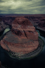 View of Horseshoe Bend, horseshoe-shaped incised meander of the Colorado River,  storm clouds in the sky, Page, Arizona, United States 