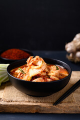Korean kimchi cabbage in a bowl on wooden with black background, Asian fermented food, Still Life